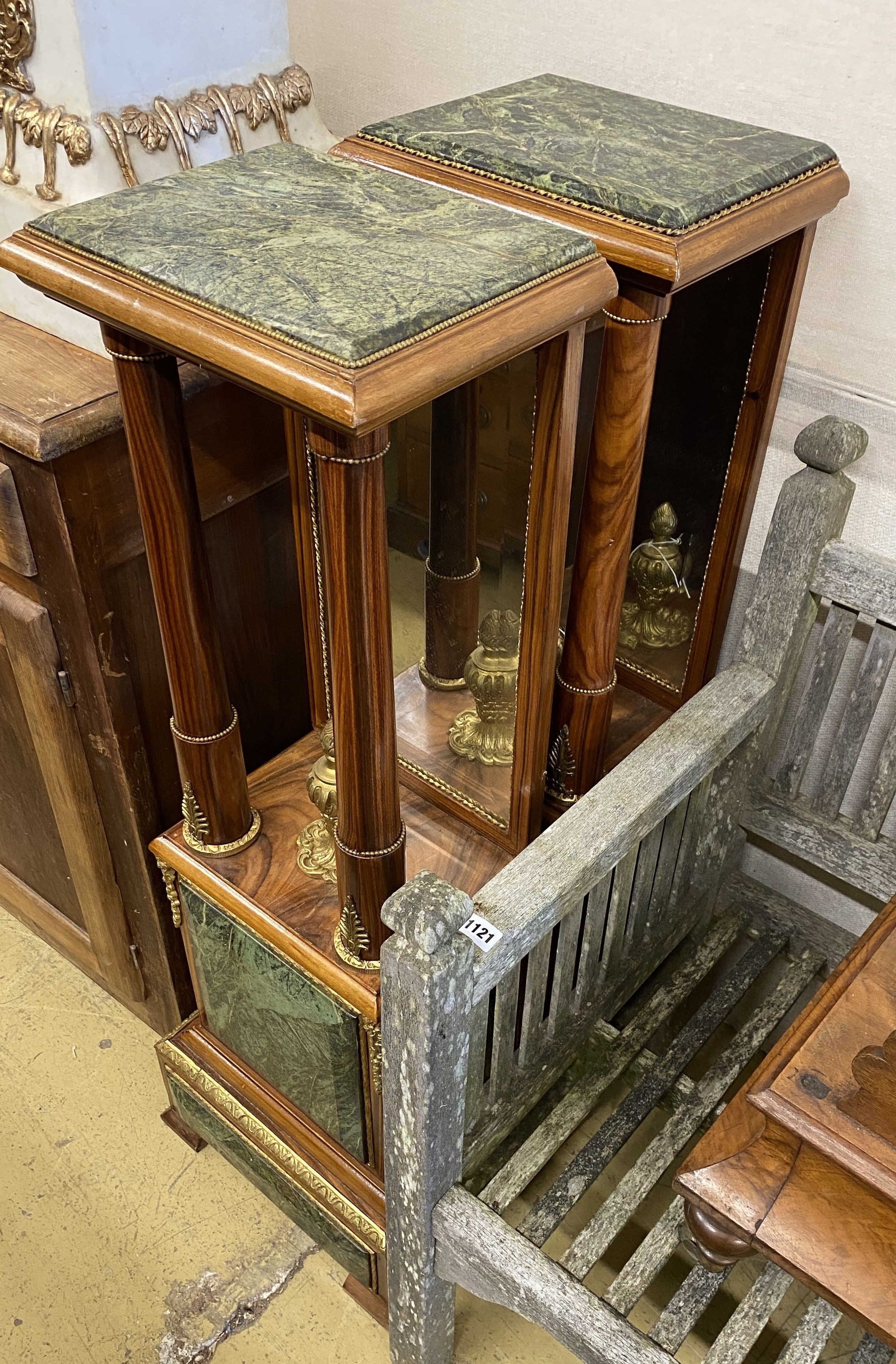 A pair of Empire style gilt metal mounted walnut mirrored pier tables, width 34cm, depth 24cm, height 109cm